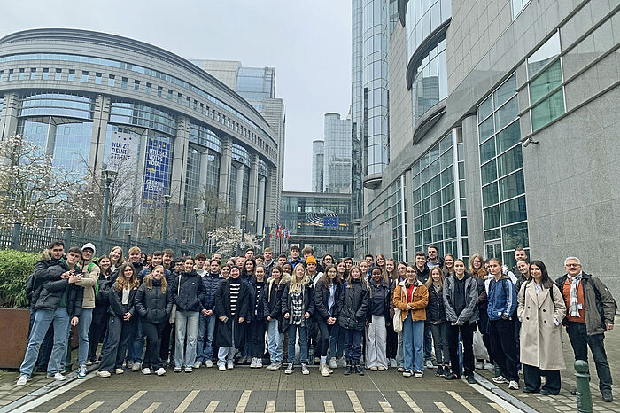 eine Gruppe Schülerinnen und Schüle und ihre Lehrkräfte stehen in Brüssel vor dem Europaparlament