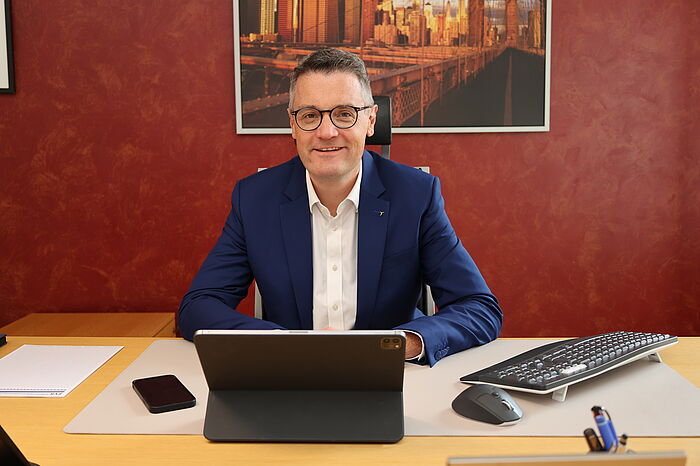 Dr. Grüttemeier sitzt am Schreibtisch vor einem Laptop.