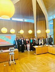 Gruppe von stehenden Menschen in Konferenzraum