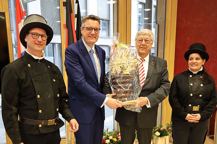 Herbert May (2.v.r.) überreicht den traditionellen Baumkuchen an Städteregionsrat Dr. Tim Grüttemeier (3.v.r.).